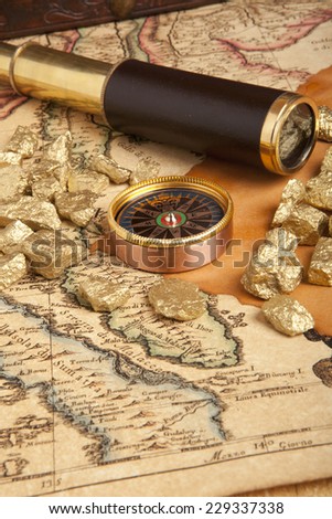 Gold nuggets and vintage brass telescope on antique map