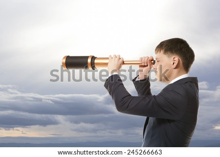 Business concept. Businessman looks through a telescope