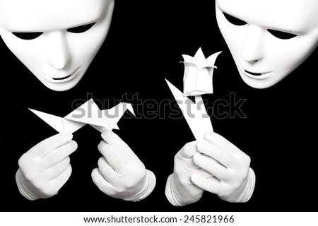 White theatrical mask and paper origami isolated on black