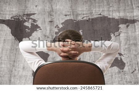 Businessman leaning back looking at world map