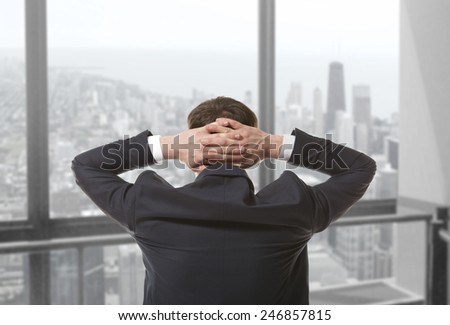 Young businessman looking out of a window