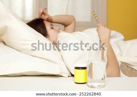 Female in bed at home caught cold, feeling bad, taking medicines, sleeping