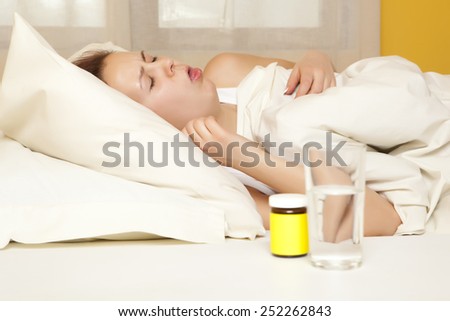 Cough. Female in bed at home caught cold, feeling bad, taking medicines