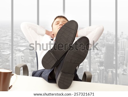 Businessman sleeping. Businessman reclining with his feet up on desk in office