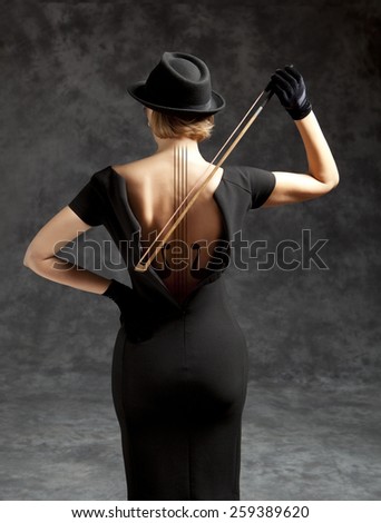 Woman in a black dress and black hat plays the violin. Photo compilation, photo and hand-drawing elements combined