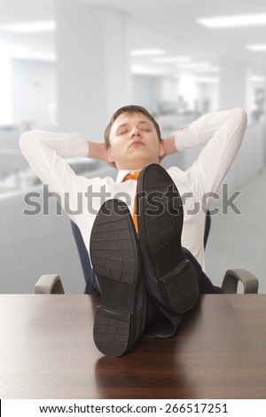 Businessman sleeping. Businessman reclining with his feet up on desk in office