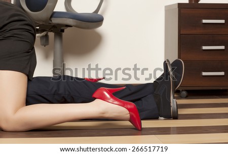 Flirting. Low section of business couple getting intimate on floor in office
