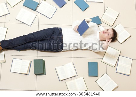 Man reading a book, top view. Blurred text is unreadable