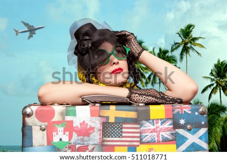 Woman traveler embraces a vintage suitcase. Suitcase with stamps flags representing each country traveled. Photo in old image style
