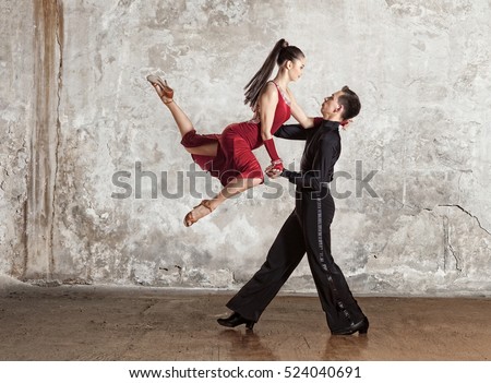 Dance beautiful couple dancing ballroom dancing on wall background. Toned image