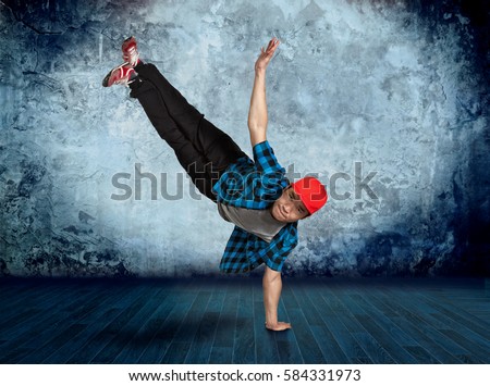 Young man break dancing on wall background