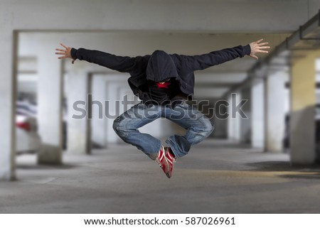 Levitation. Young man break dancing on wall background