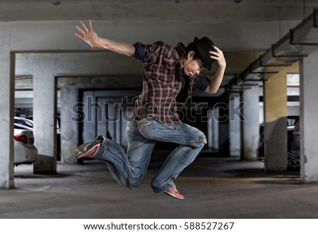 Levitation. Young man break dancing on wall background