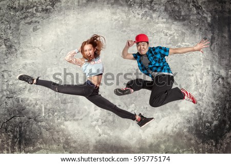 Young couple break dancing on wall background