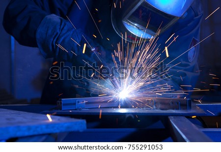 Welder erecting technical steel. Industrial steel welder in factory technical