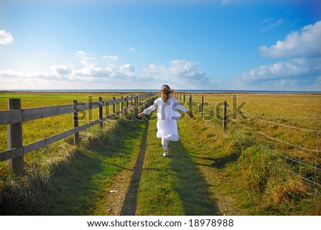 The teenager relaxing on the meadow, the way leading to the sea
