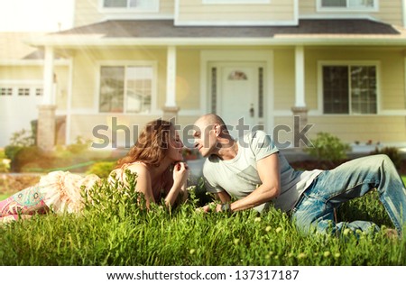 Happy Couple near their Home.Smiling Family outdoor.Real Estate