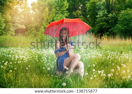 a girl caught in a rain shower under her umbrella