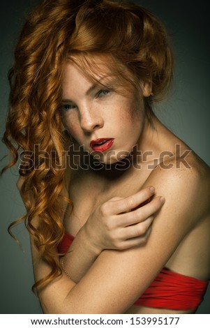 portrait of red-haired freckled young woman with beautiful long wavy hair