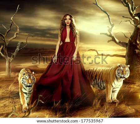 fashionable young attractive and sensuality woman in the desert in long red dress with tigers near her