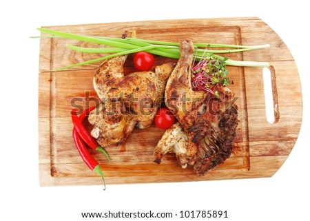 grilled meat : chicken quarters garnished with green sprouts and red peppers on wooden plate isolated over white background
