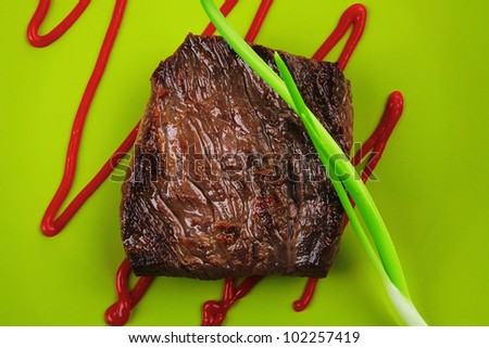 meat food : roast beef fillet mignon served on green plate with chives and ketchup isolated over white background
