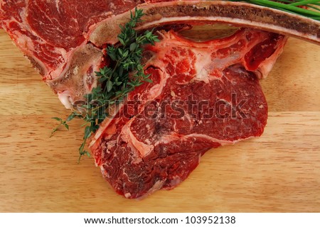 fresh meat : raw beef spare ribs with thyme and green chives on wooden board isolated over white background