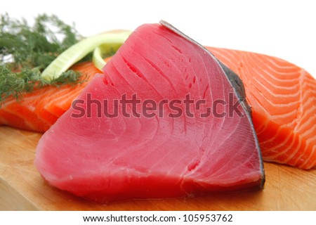 pieces of salmon and tuna fish on wooden plate isolated on white background