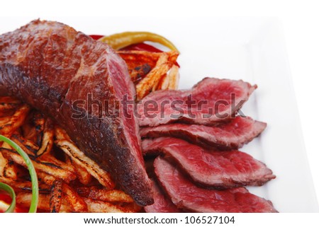 meat and potato : rare grilled beef steak served with pepper and tomato over plate isolated on white background