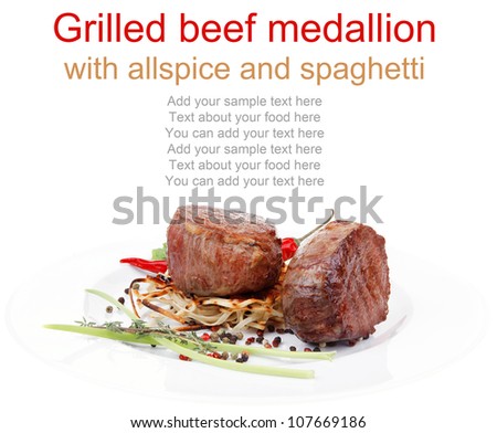 grilled beef fillet medallions with thyme and red hot chili pepper on plate isolated over white background