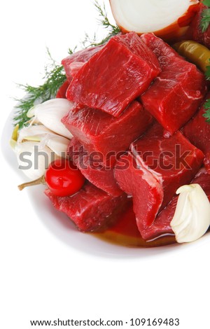 raw fresh beef meat slices in a white bowls with onion and red peppers isolated over white background