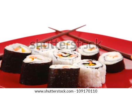Maki Sushi : Maki Rolls and California rolls made of fresh raw Salmon, Tuna and Eel . on red dish with sticks isolated over white background