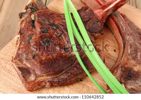 served main course: grilled pork ribs served with green chives over wooden plate