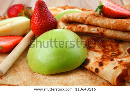 baked food : pancake with honey strawberries and apple on wooden table