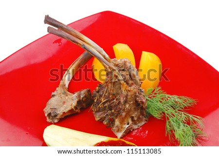 main entree : grilled beef small ribs served with mango fruit and filled avocado on red dish isolated over white background