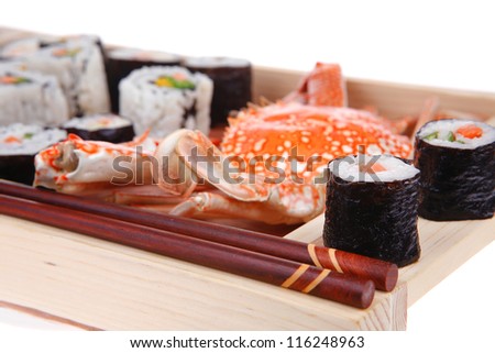 Roll with Cucumber , Cream Cheese with raw Tuna and Salmon inside. on wooden plate with live crab  . Isolated over white background . Japanese traditional Cuisine