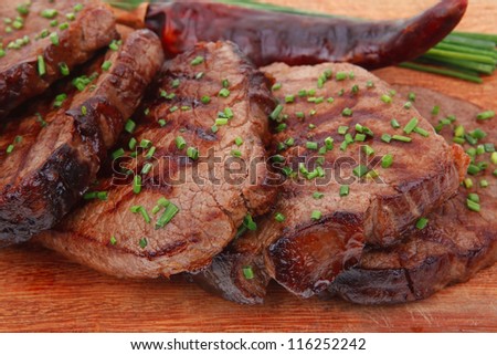 business lunch roasted beef meat fillet on wooden plate with thyme and chives isolated on white background