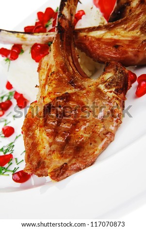 main course: grilled ribs with rice and tomatoes on white plate over white background