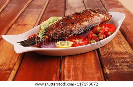 main course: whole fried seabass served on wood with lemons,tomatoes and peppers