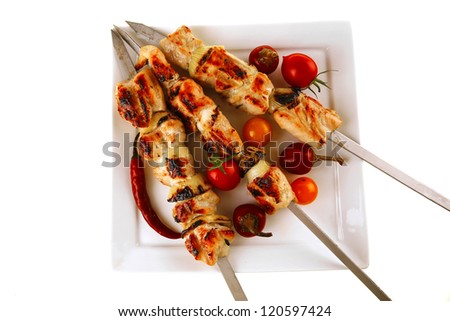 chicken shish kebab on white platter with vegetables