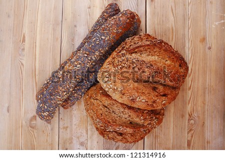 delicacy french rye breads and baguettes topped with sunflower and poppy seeds over wooden table