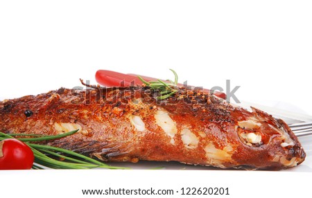 main course isolated on white: whole fried sunfish on plate with lemons and peppers