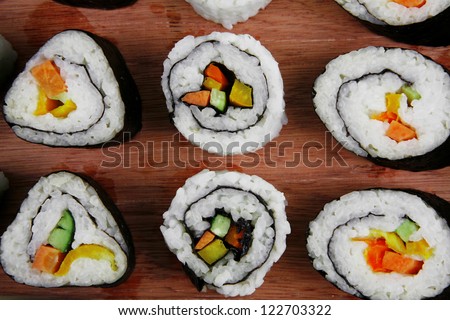 Japanese Cuisine - Maki Roll with Deep Fried Vegetables inside . on wooden plate . isolated over white background