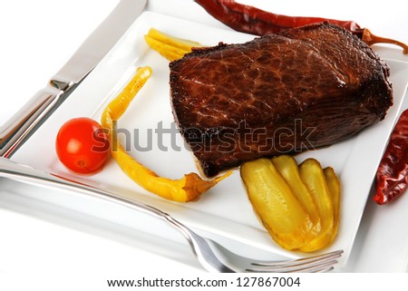 meat chunk served on white with knive and fork