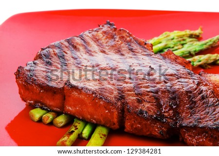 meat table : rare medium roast beef fillet asparagus served on red dish isolated over white