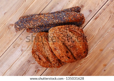 delicacy french rye breads and baguettes topped with sunflower and poppy seeds over wooden table