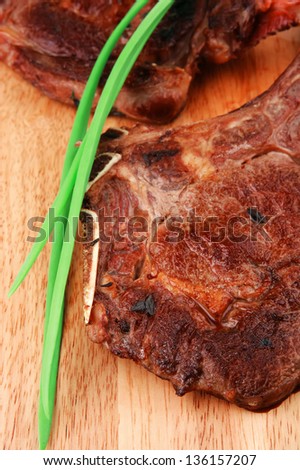 meat savory : grilled beef ribs served with green chives on wooden table