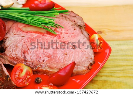 hot ham served on red dish over wooden table