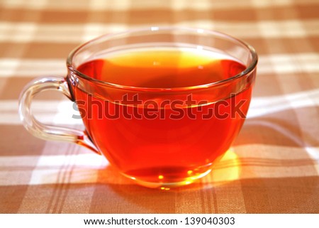 hot tea in transparent mug on tablecloth
