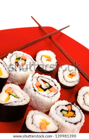 Japanese Traditional Cuisine - California Roll with Avocado and Salmon, Cream Cheese . on red dish with sticks isolated over white background